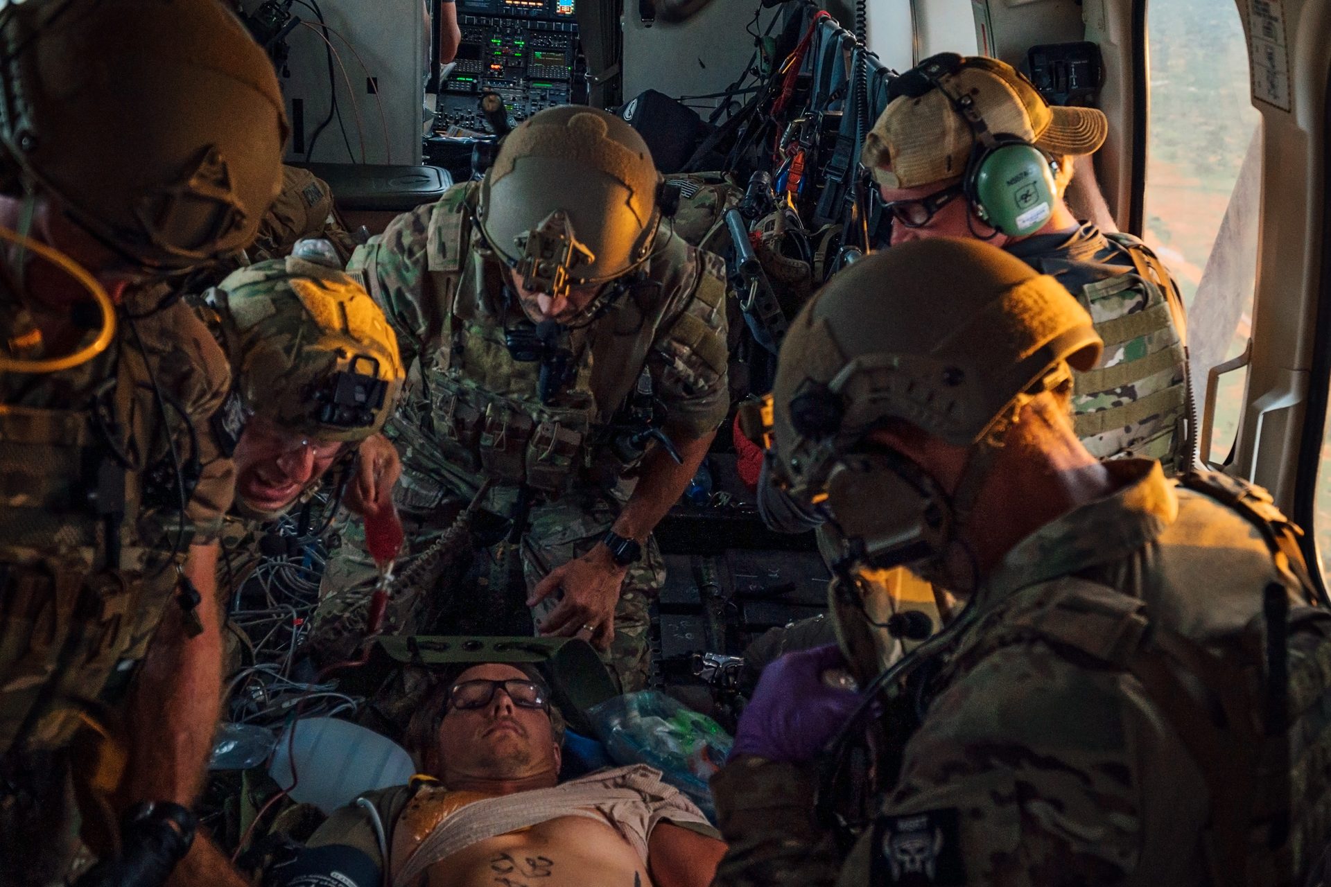 PJ operators performing in-flight medical treatment inside helicopter